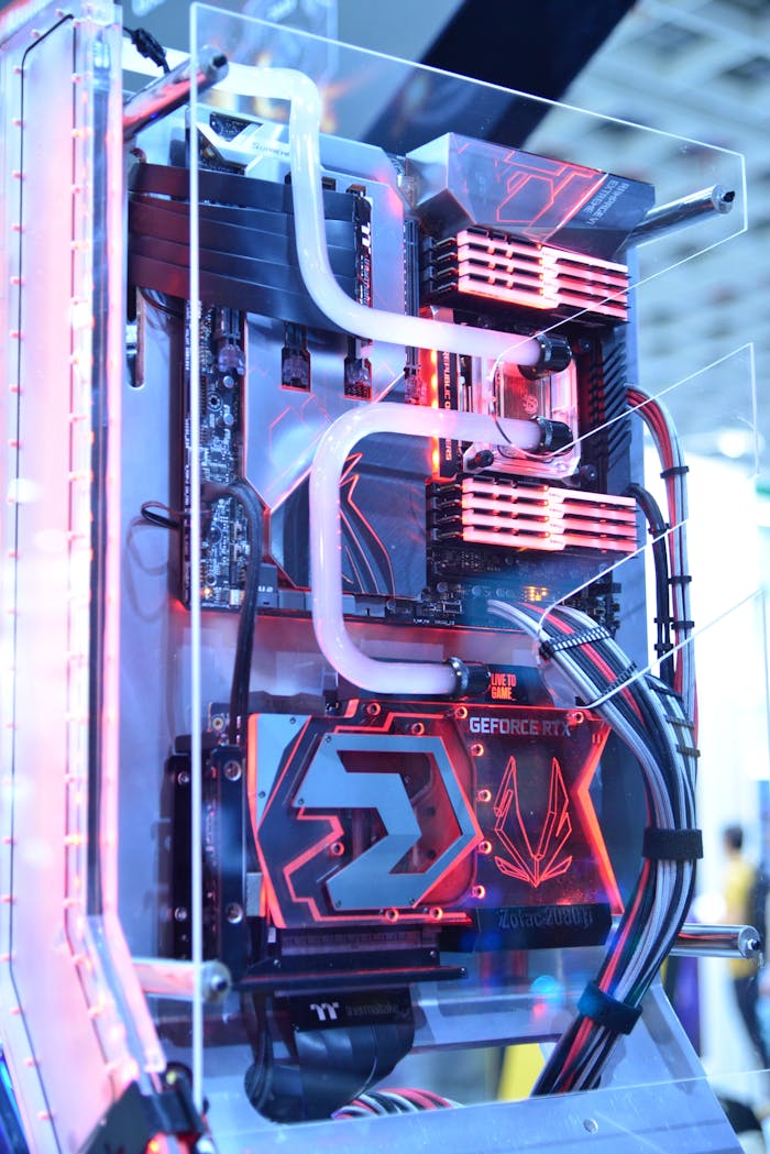 ours-journey Close-up view of a custom gaming PC with water cooling and LED lights, highlighting advanced technology.