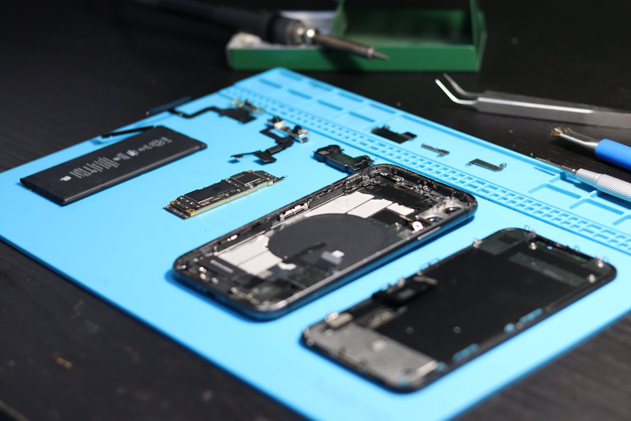 gallery-6 Disassembled smartphone with tools on a workbench, emphasizing repair and technology.